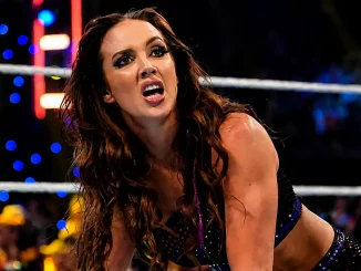 Chelsea Green erschöpft und sichtlich angespannt im WWE-Ring, während im Hintergrund die hell erleuchtete Arena und das Publikum zu sehen sind