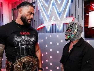 Roman Reigns und Rey Mysterio stehen sich in der Gorilla Position bei WWE RAW im Backstagebereich gegenüber und schauen sich an