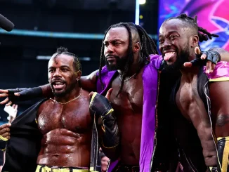 Austin Creed, Kofi und Swerve Strickland stehen nach einem Match eng beieinander, während sie vor jubelnden Fans und laufenden Kameras gemeinsam für einen ausgelassenen Moment posieren