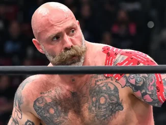 Andy „The Butcher“ Williams ist im Wrestling-Ring mit ernstem Blick, tätowiertem Oberkörper und rotem Tape an der Schulter zu sehen