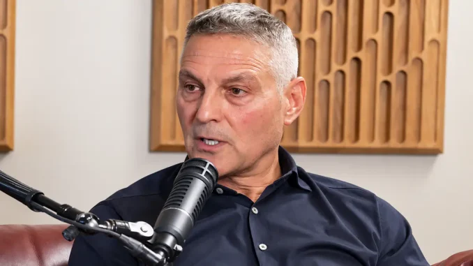 Ari Emanuel sitzt in einem Podcast- bzw. Interviewstudio vor einem Mikrofon und spricht mit ernstem, konzentriertem Gesichtsausdruck.