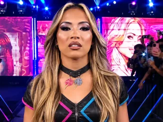Lola Vice beim WWE Entrance vor farbenfrohen LED-Wänden und Fans, die sie mit ihren Smartphones filmen