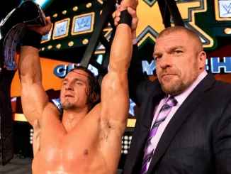 PAC präsentiert den Champion-Titel, während Triple H an seiner Seite seinen Arm zum Sieg in die Höhe hält