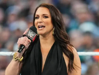 Stephanie McMahon steht in einem WWE-Ring und spricht mit einem Mikrofon in der Hand vor dem Publikum