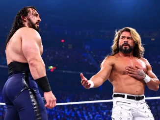 Das Bild zeigt PAC links und Andrade rechts, die sich in einem Wrestling-Ring gegenüberstehen und einander angespannt ansehen.