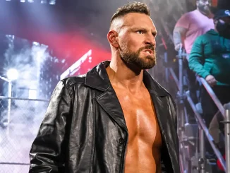 Das Bild zeigt Dijak mit verärgertem Blick und schwarzer Lederjacke bei seinem Auftritt in einer Wrestling-Arena, während im Hintergrund Fans, Scheinwerfer und Bühnennebel zu sehen sind.
