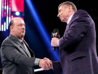 Paul Heyman und Vince McMahon geben sich im WWE-Ring die Hand. McMahon hält ein WWE-Mikrofon.