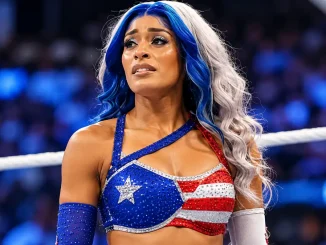 Zelina Vega mit ihren blau-silbernen Haaren und dem rot-weiß-blauen Oberteil steht im Wrestling-Ring.